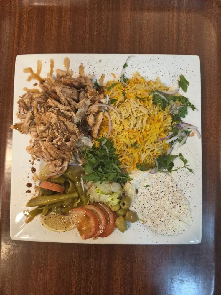 Arabic chicken shawarma served with saffron rice, garlic sauce, salad and pickles