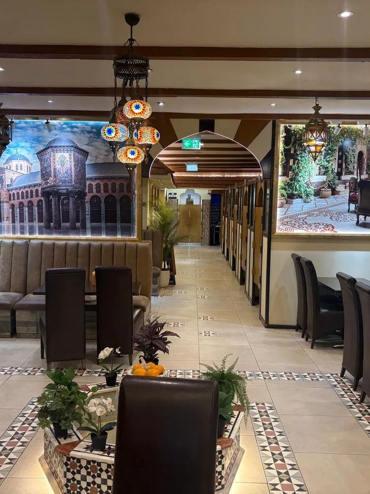 Dining room at Syrian House — backlit murals of the Umayyad Mosque, mosaic lanterns and cosy booths